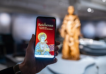 Smartphone mit der App "Reichenau - Der Guide zum Welterbe des Mittelalters"